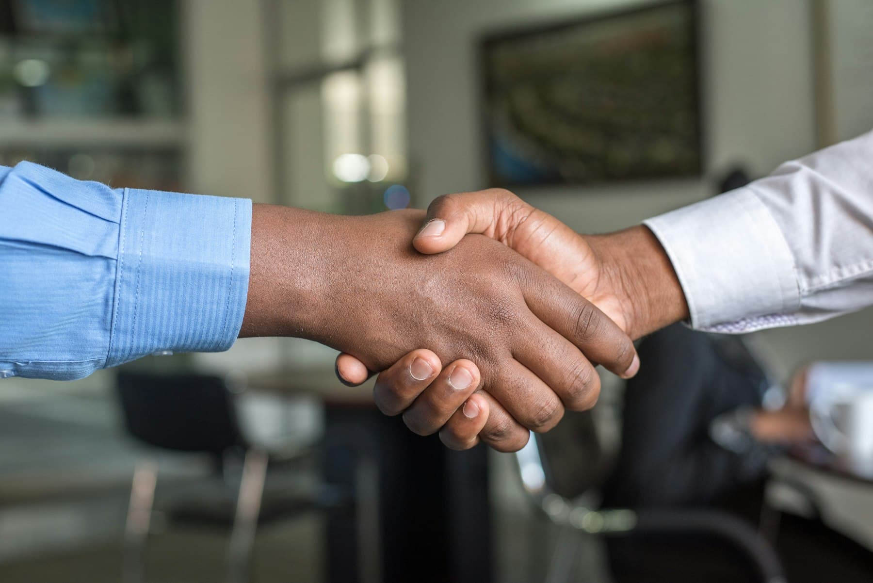 Two professionals shaking hands across a table
